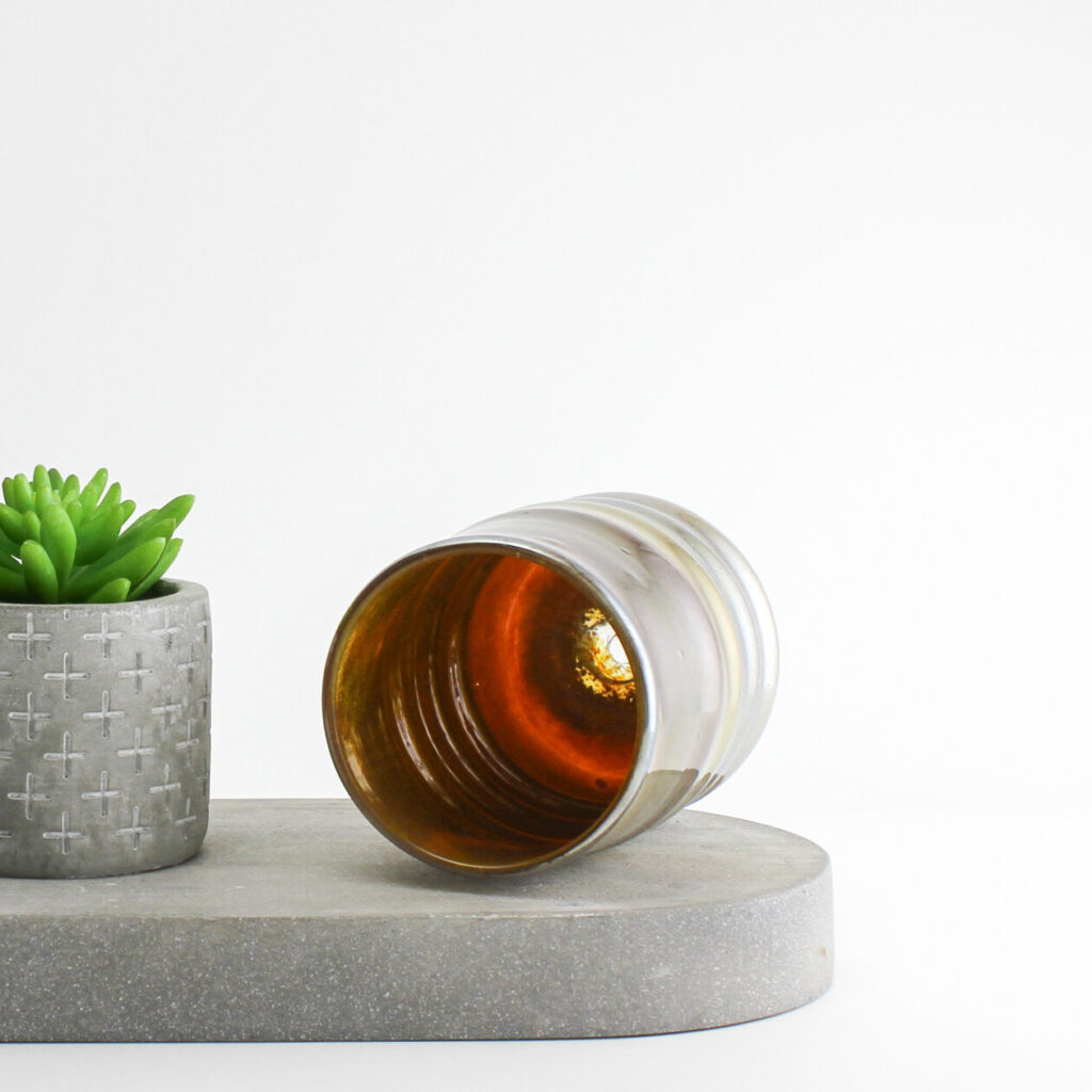 Inside surface of metallic ripple shaped handblown glass cup lying on it's side.